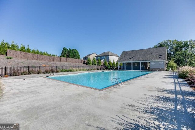 community pool featuring fence and a patio area