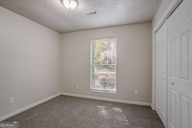 2800 Macon Dr SE, Atlanta, GA 30354 - unfurnished bedroom with a textured ceiling, carpet floors, a closet, and baseboards