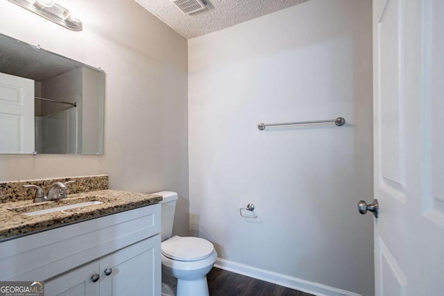 2800 Macon Dr SE, Atlanta, GA 30354 - bathroom with a textured ceiling, toilet, vanity, wood finished floors, and baseboards