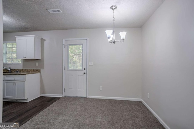 2800 Macon Dr SE, Atlanta, GA 30354 - unfurnished dining area featuring plenty of natural light, a chandelier, dark carpet, baseboards, and a textured ceiling