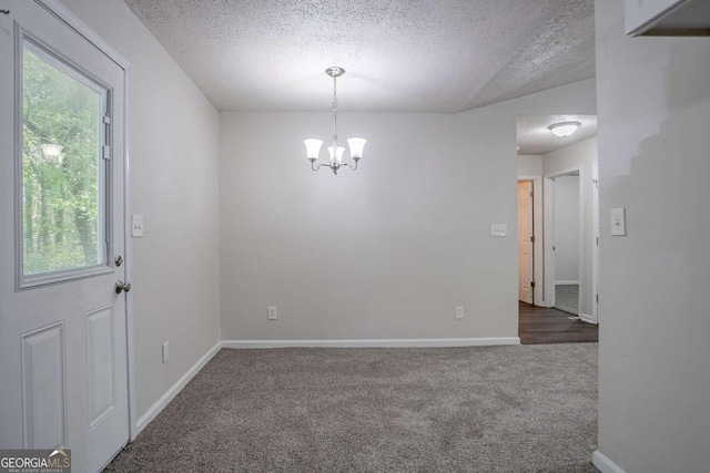 2800 Macon Dr SE, Atlanta, GA 30354 - spare room featuring a textured ceiling, healthy amount of natural light, carpet floors, a chandelier, and baseboards
