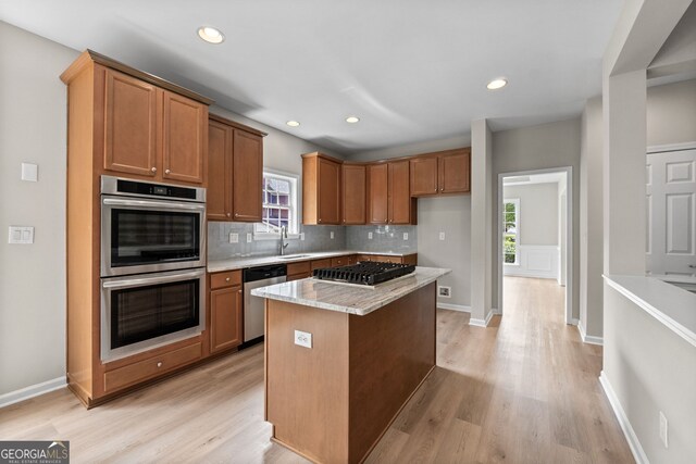 1429 Kentmire Ct, Locust Grove, GA 30248 - kitchen featuring stainless steel appliances, light wood-style flooring, decorative backsplash, brown cabinets, and recessed lighting