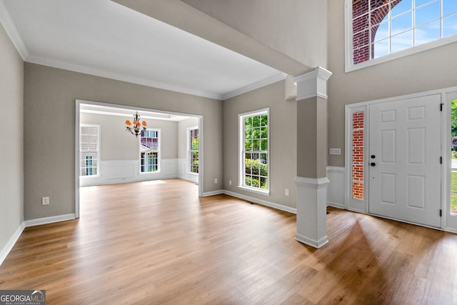 1429 Kentmire Ct, Locust Grove, GA 30248 - entrance foyer featuring decorative columns, light wood finished floors, ornamental molding, a chandelier, and baseboards