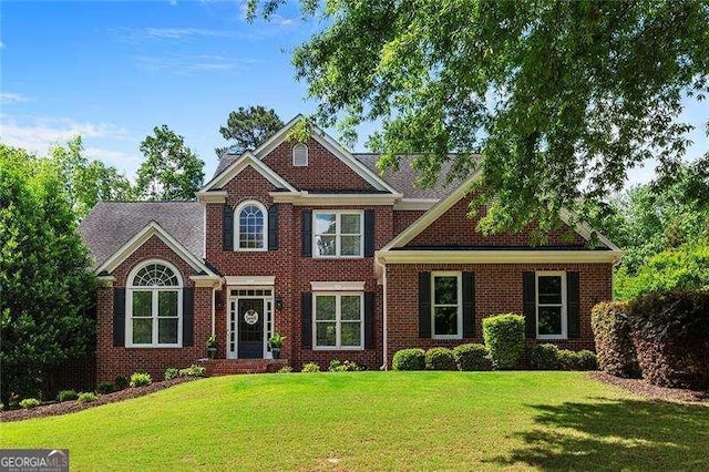 view of front of property with a front lawn and brick siding