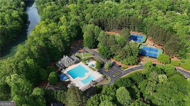 aerial overview of property's location with a pool and a forest