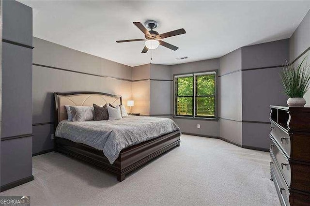 bedroom featuring light colored carpet, a ceiling fan, and baseboards