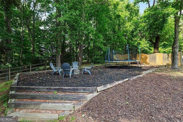view of yard featuring fence and a trampoline