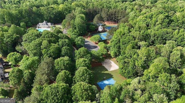 aerial view of property and surrounding area with a forest