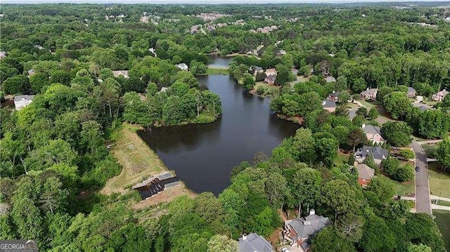 view of property location with a large body of water and a heavily wooded area