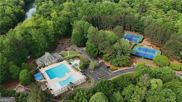 view of property location featuring a pool area and a heavily wooded area