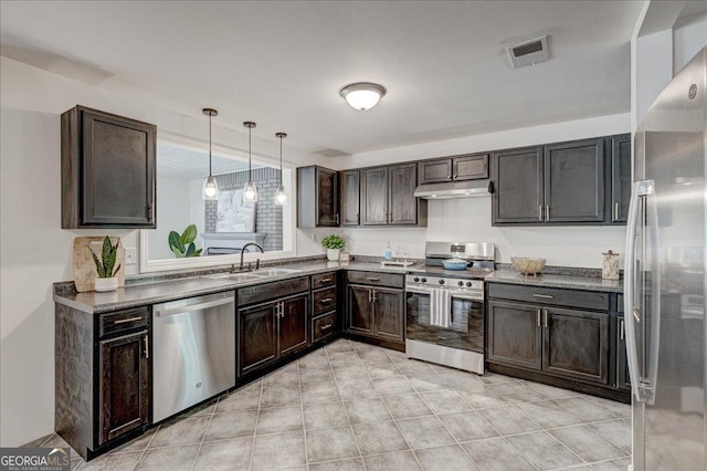 kitchen featuring stainless steel appliances, a sink, under cabinet range hood, dark brown cabinetry, and decorative light fixtures