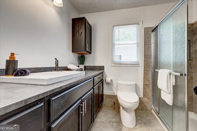 full bathroom featuring toilet, a stall shower, vanity, a textured ceiling, and baseboards