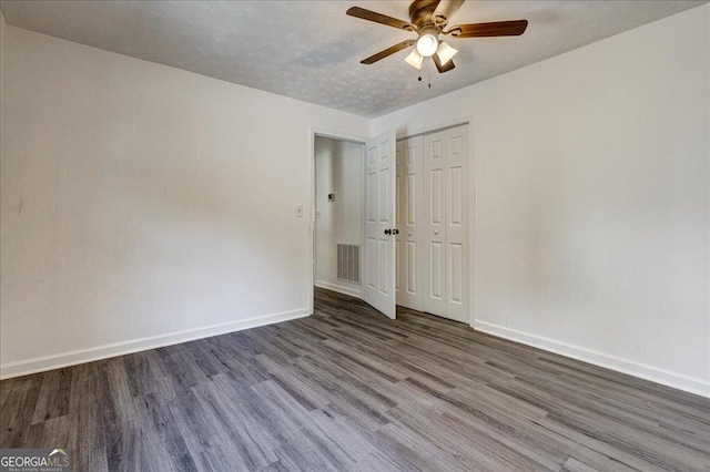 unfurnished room featuring baseboards, wood finished floors, and a ceiling fan