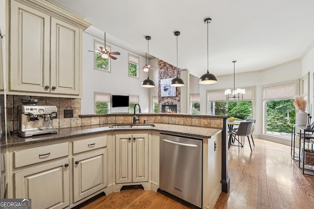 3282 Green Farm Trl, Dacula, GA 30019 - kitchen with cream cabinetry, stainless steel dishwasher, a sink, a fireplace, and ornamental molding