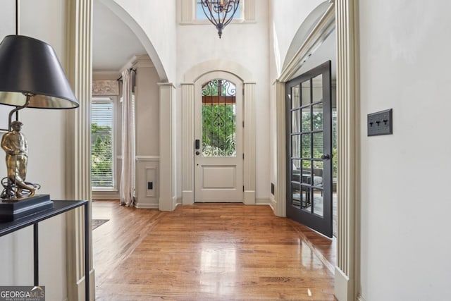 3282 Green Farm Trl, Dacula, GA 30019 - entryway with arched walkways, light wood-style flooring, a chandelier, and a towering ceiling