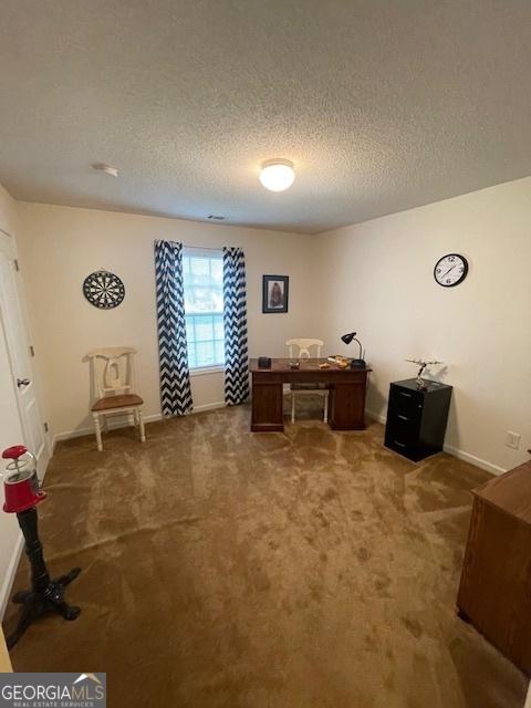 home office featuring carpet, a textured ceiling, and baseboards