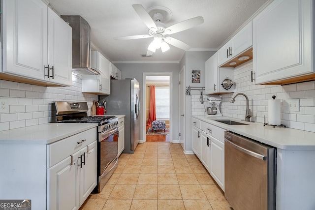 kitchen with stainless steel appliances, wall chimney range hood, a sink, a ceiling fan, and ornamental molding