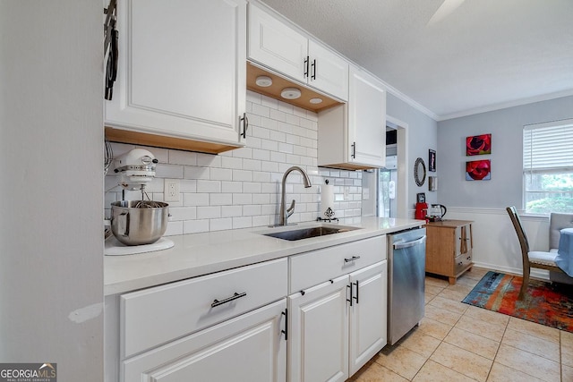 kitchen with dishwasher, a sink, tasteful backsplash, light countertops, and crown molding
