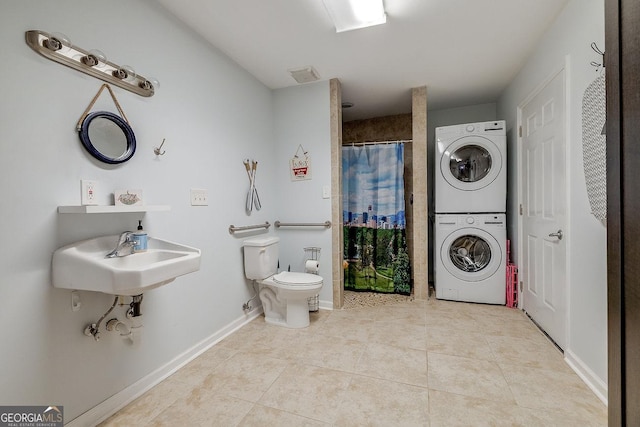 full bath with stacked washer / drying machine, toilet, tile patterned flooring, curtained shower, and a sink