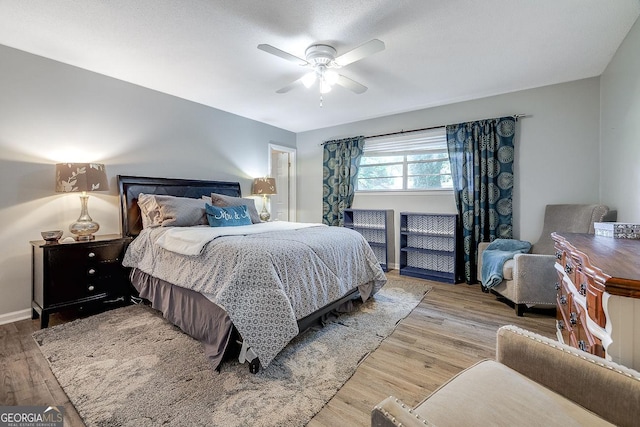 bedroom with wood finished floors, ceiling fan, and baseboards