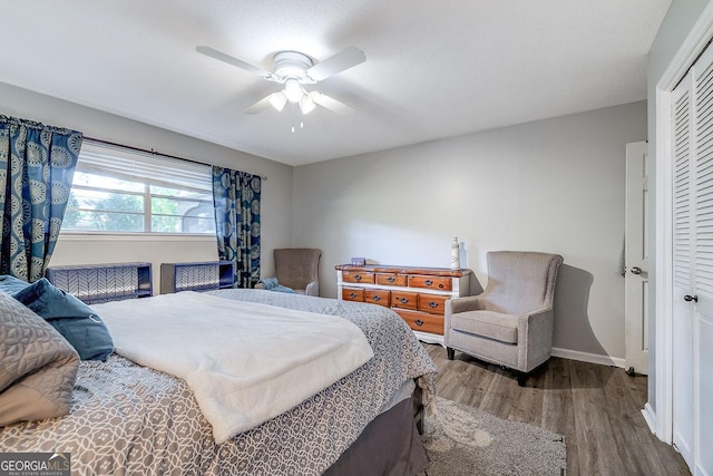 bedroom with a closet, wood finished floors, ceiling fan, and baseboards