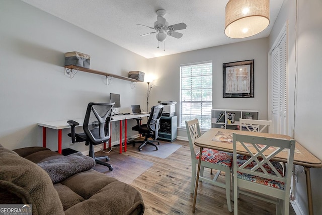 office area featuring a ceiling fan, wood finished floors, baseboards, and a textured ceiling