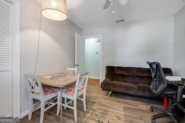 dining area with wood finished floors, a ceiling fan, and baseboards