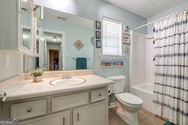 full bathroom featuring toilet, vanity, tile patterned floors, shower / bath combo with shower curtain, and a textured ceiling