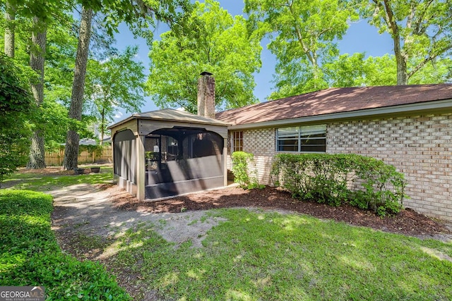 back of property with a chimney, a gazebo, a garage, brick siding, and roof with shingles