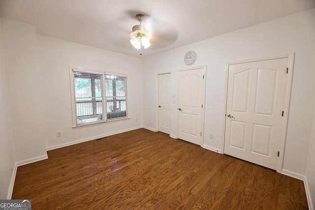 1425 Turtle Dove Ln, Lawrenceville, GA 30043 - unfurnished bedroom featuring multiple closets, dark wood-style floors, and a ceiling fan