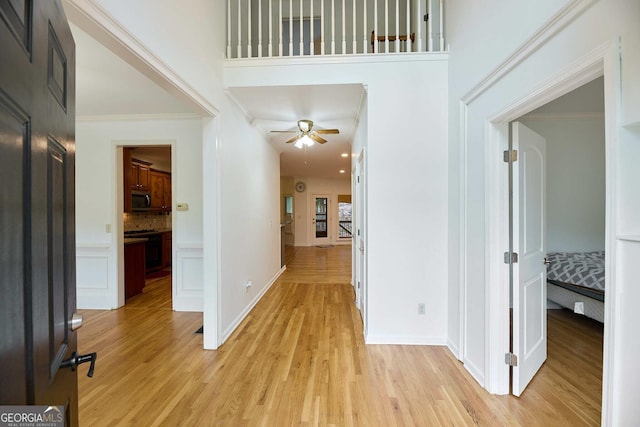 1425 Turtle Dove Ln, Lawrenceville, GA 30043 - hallway with light wood-style flooring, a high ceiling, and ornamental molding