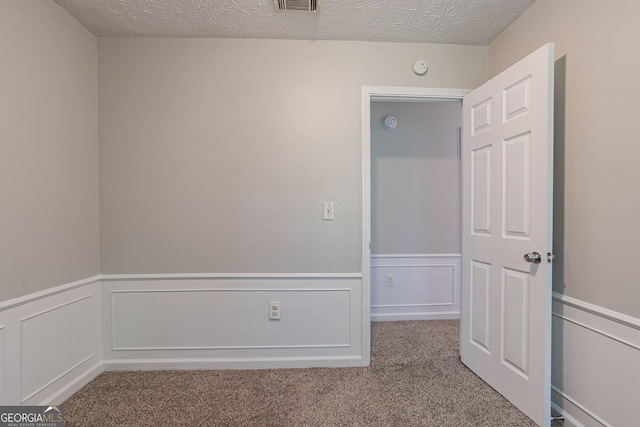 1076 Plantation Blvd SE, Conyers, GA 30094 - unfurnished room featuring wainscoting, carpet floors, a decorative wall, a textured ceiling, and a smoke detector