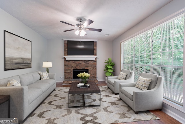 1076 Plantation Blvd SE, Conyers, GA 30094 - living area featuring wood finished floors, plenty of natural light, ceiling fan, and a fireplace