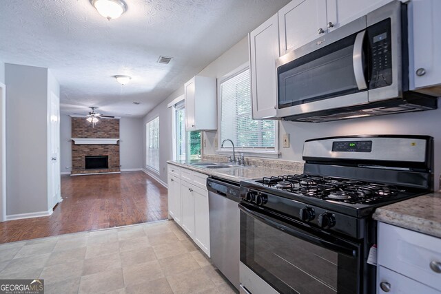 1076 Plantation Blvd SE, Conyers, GA 30094 - unfurnished living room with a ceiling fan, a textured ceiling, wood finished floors, and baseboards
