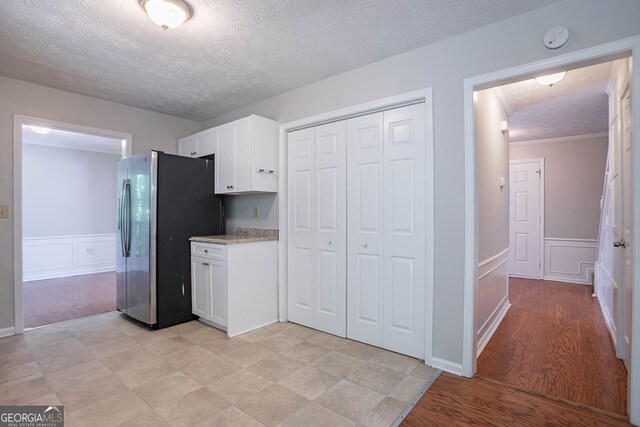 1076 Plantation Blvd SE, Conyers, GA 30094 - kitchen with appliances with stainless steel finishes, a sink, white cabinetry, a textured ceiling, and baseboards
