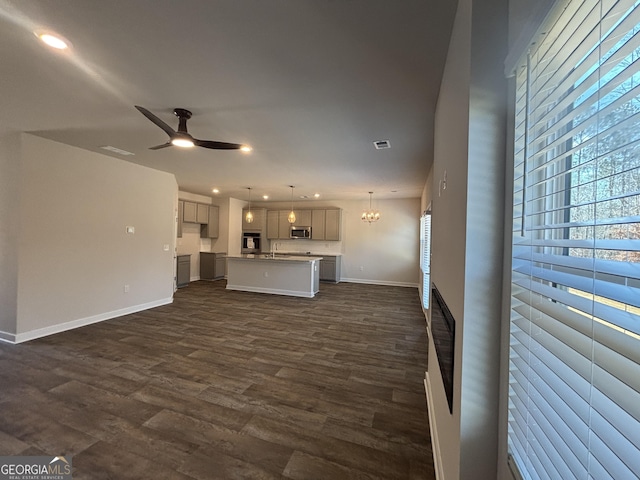unfurnished living room featuring plenty of natural light, ceiling fan, dark wood-style floors, baseboards, and recessed lighting