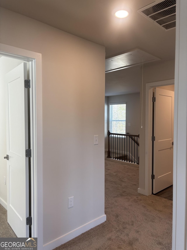 corridor with attic access, carpet floors, baseboards, an upstairs landing, and recessed lighting