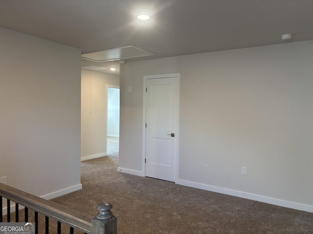empty room featuring attic access, dark colored carpet, baseboards, recessed lighting, and a smoke detector