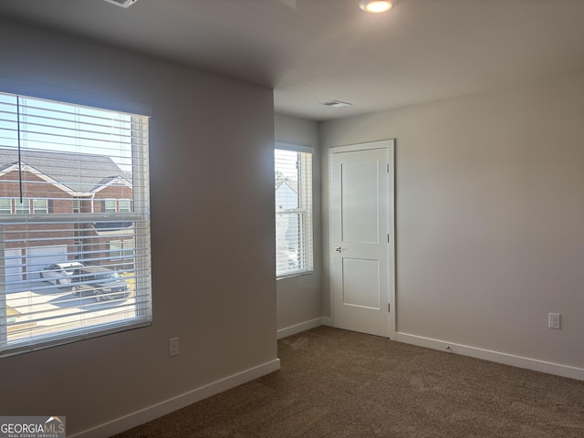 empty room featuring carpet floors and baseboards