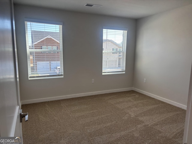 carpeted spare room featuring baseboards