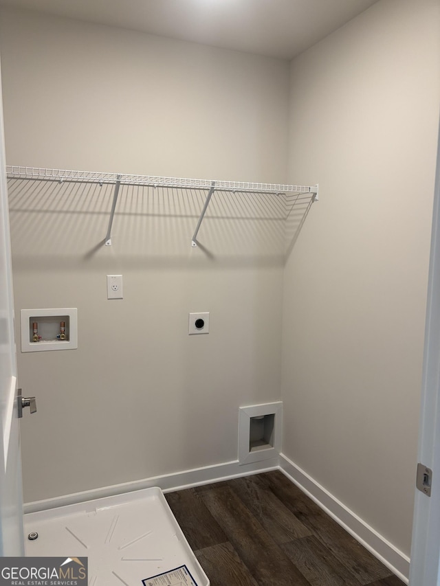 washroom with dark wood-style flooring, hookup for an electric dryer, hookup for a washing machine, and baseboards