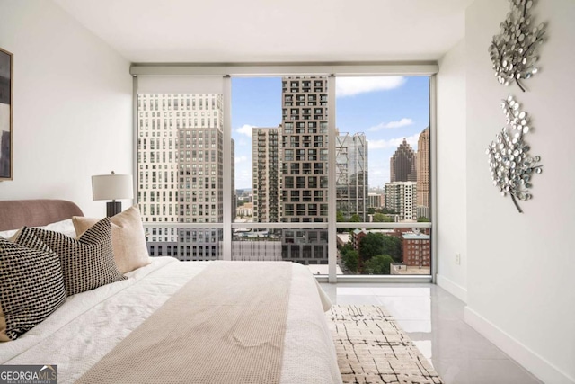 20 10th St NW Unit 2003, Atlanta, GA 30309 - bedroom featuring a wall of windows, a view of skyline, tile patterned floors, and baseboards