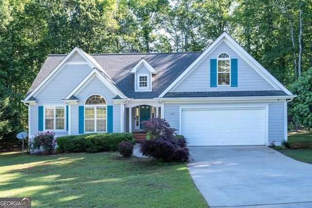view of front of home featuring concrete driveway, a front yard, a shingled roof, and a garage