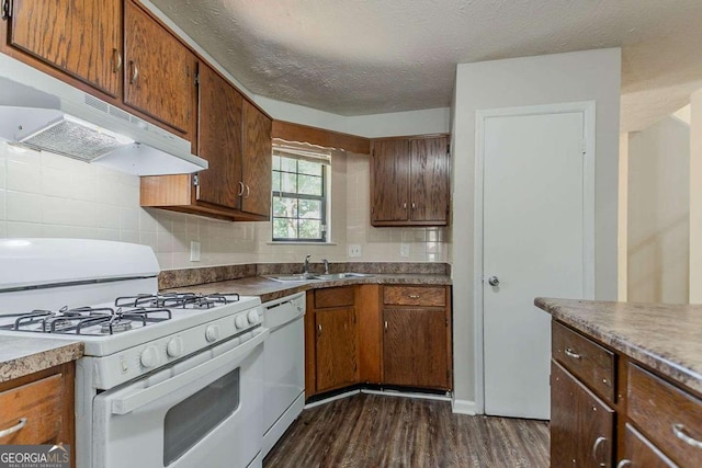 1074 Cherokee Hts, Stone Mountain, GA 30083 - kitchen with white appliances, under cabinet range hood, dark wood finished floors, tasteful backsplash, and a textured ceiling