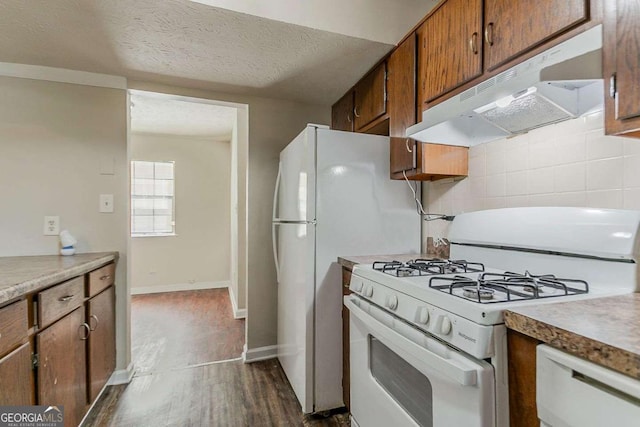 1074 Cherokee Hts, Stone Mountain, GA 30083 - kitchen with white gas stove, under cabinet range hood, dark wood-type flooring, light countertops, and backsplash