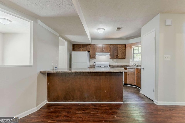1074 Cherokee Hts, Stone Mountain, GA 30083 - kitchen with freestanding refrigerator, under cabinet range hood, dark wood finished floors, light countertops, and a textured ceiling