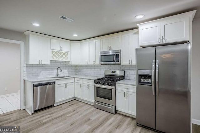 3735 Boulder Park Dr SW, Atlanta, GA 30331 - kitchen featuring appliances with stainless steel finishes, a sink, white cabinetry, baseboards, and decorative backsplash