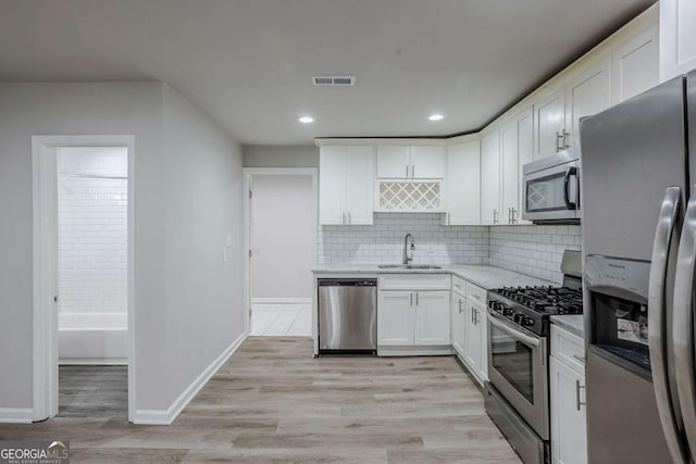 3735 Boulder Park Dr SW, Atlanta, GA 30331 - kitchen featuring stainless steel appliances, a sink, white cabinets, backsplash, and baseboards