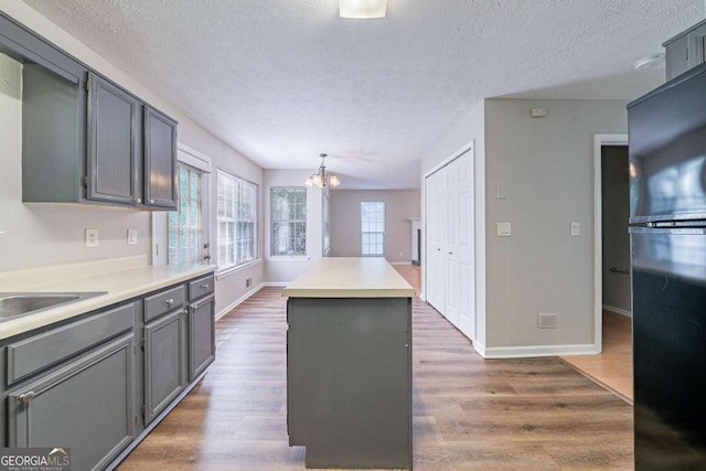 12237 Cypress Ln, Fayetteville, GA 30215 - kitchen with freestanding refrigerator, gray cabinets, a chandelier, a center island, and a textured ceiling