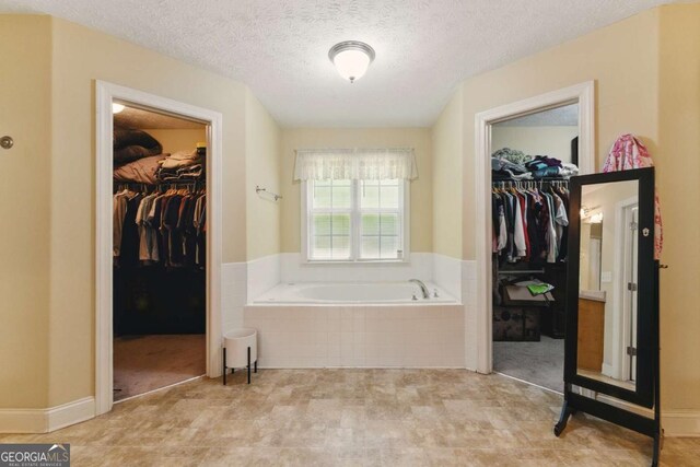 418 Whisper Wood Way, Locust Grove, GA 30248 - full bath with a bath, a textured ceiling, and a walk in closet